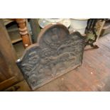 Cast iron fire back decorated in high relief with a lion (at fault), a fire grate, dogs, kerb and