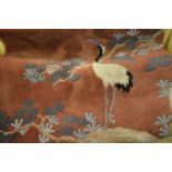 Chinese woollen rug having bird decoration on a burgundy ground