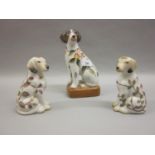 Porcelain figure of a seated dog decorated with fruit, insects and foliage together with a pair of