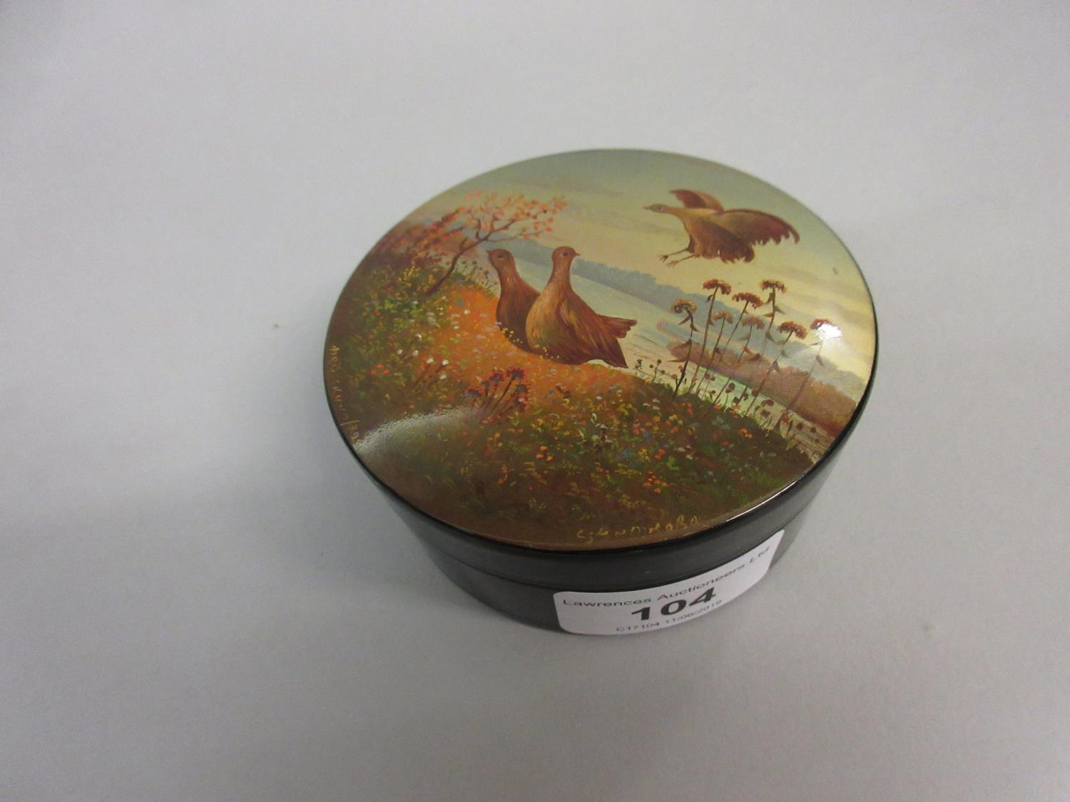 Russian circular papier mache box, the cover painted with game birds in a landscape, signed