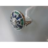 Unusual platinum circular ring set with a central diamond surrounded by sapphires and emeralds