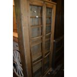 Early 20th Century stripped pine two door bookcase, the glazed doors enclosing five shelves, 74ins