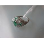 Victorian style platinum ring set emeralds and diamonds in a filigree style mount
