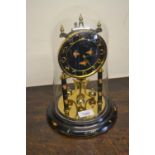 Brass and black lacquered anniversary clock under glass dome together with a walnut dome shaped