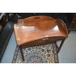 19th Century mahogany butlers tray / table, the drop-down sides with gilt brass hinges enclosing a