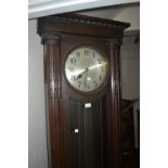 Oak longcase clock circa 1930, the rectangular case with flanking pilasters, the circular silvered