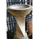 Circular stone bird bath on a spiral twist column