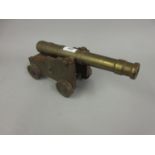 Model of a canon, the brass barrel on iron carriage, with iron wheels, 12ins long, together with a