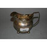 George III silver cream jug with banded engraved floral decoration and ball feet