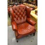 Reproduction mahogany red buttoned leather upholstered wing back armchair on square moulded front