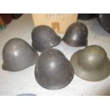 Group of five World War II and later military helmets