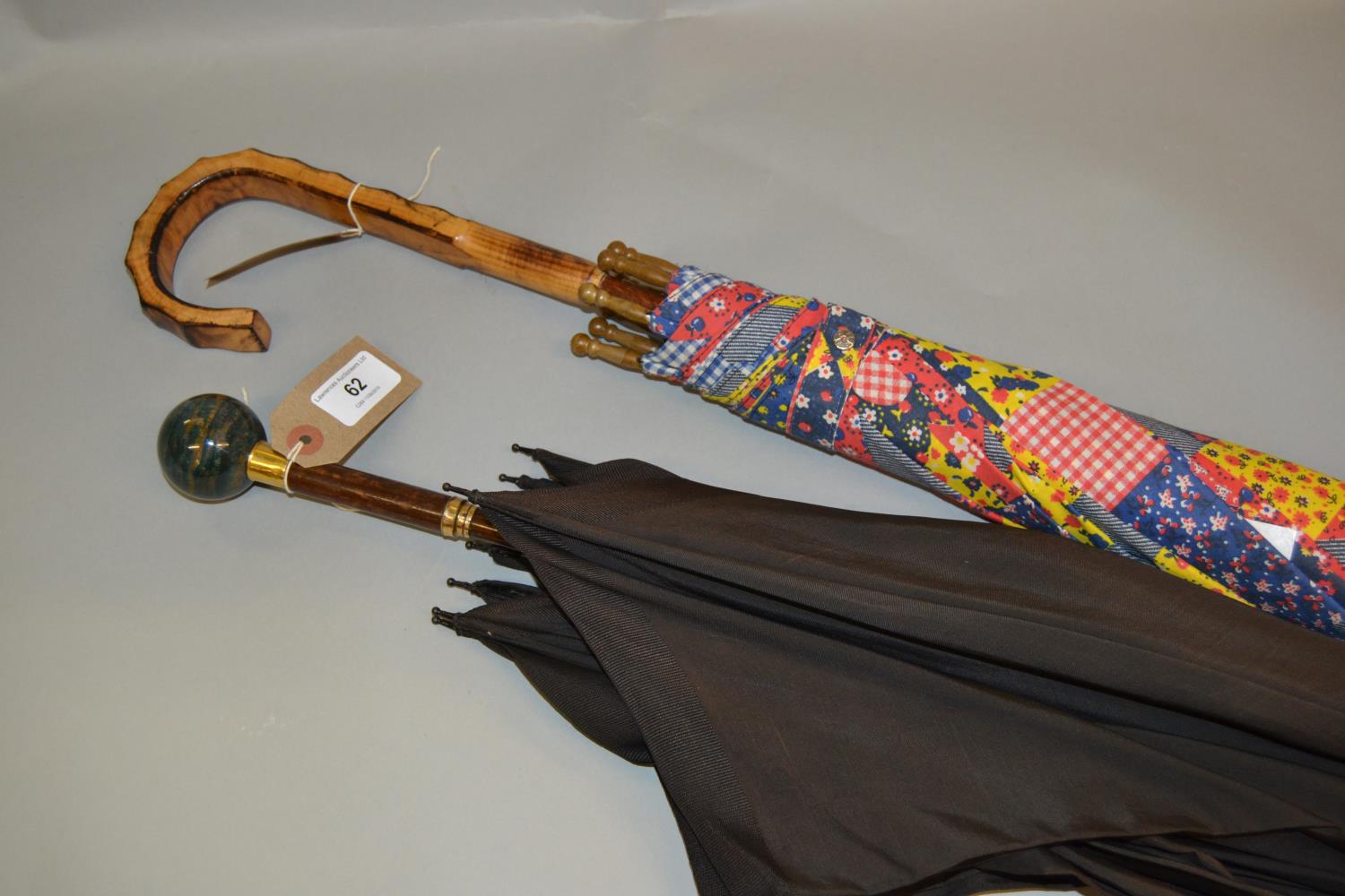 Black silk parasol with hardstone handle together with another floral decorated parasol