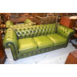 Green button leather upholstered three seat Chesterfield sofa together with a matching armchair