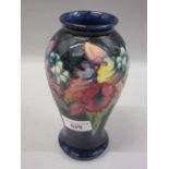 Mid 20th Century Moorcroft baluster form vase tubeline decorated with flowers on a dark blue ground,