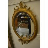 Oval gilt framed bevelled edge wall mirror with triple candle holder bracket