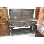 Victorian oak buffet with an earlier carved panel back above two frieze drawers, raised on turned