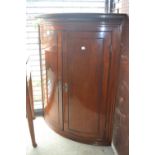 George III mahogany two door bow front hanging corner cabinet with a moulded dentil cornice