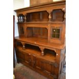 Early 20th Century oak sideboard in Arts and Crafts style, the moulded canopy top above a pair of