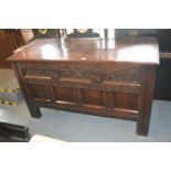 17th Century oak coffer, the hinged moulded lid above a carved frieze and four panel front raised on