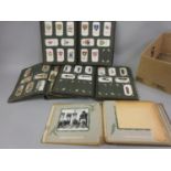 Three albums containing a large quantity of cigarette cards and an album of postcards