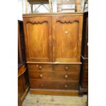 Victorian mahogany linen press with a pair of arched doors above two short and two long drawers on a