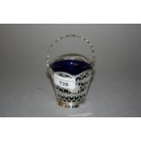 Small George III silver bonbon basket of pierced tapering design with swing handle and a blue