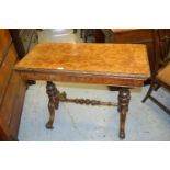 Victorian rectangular figured walnut fold-over card table on turned carved end supports with