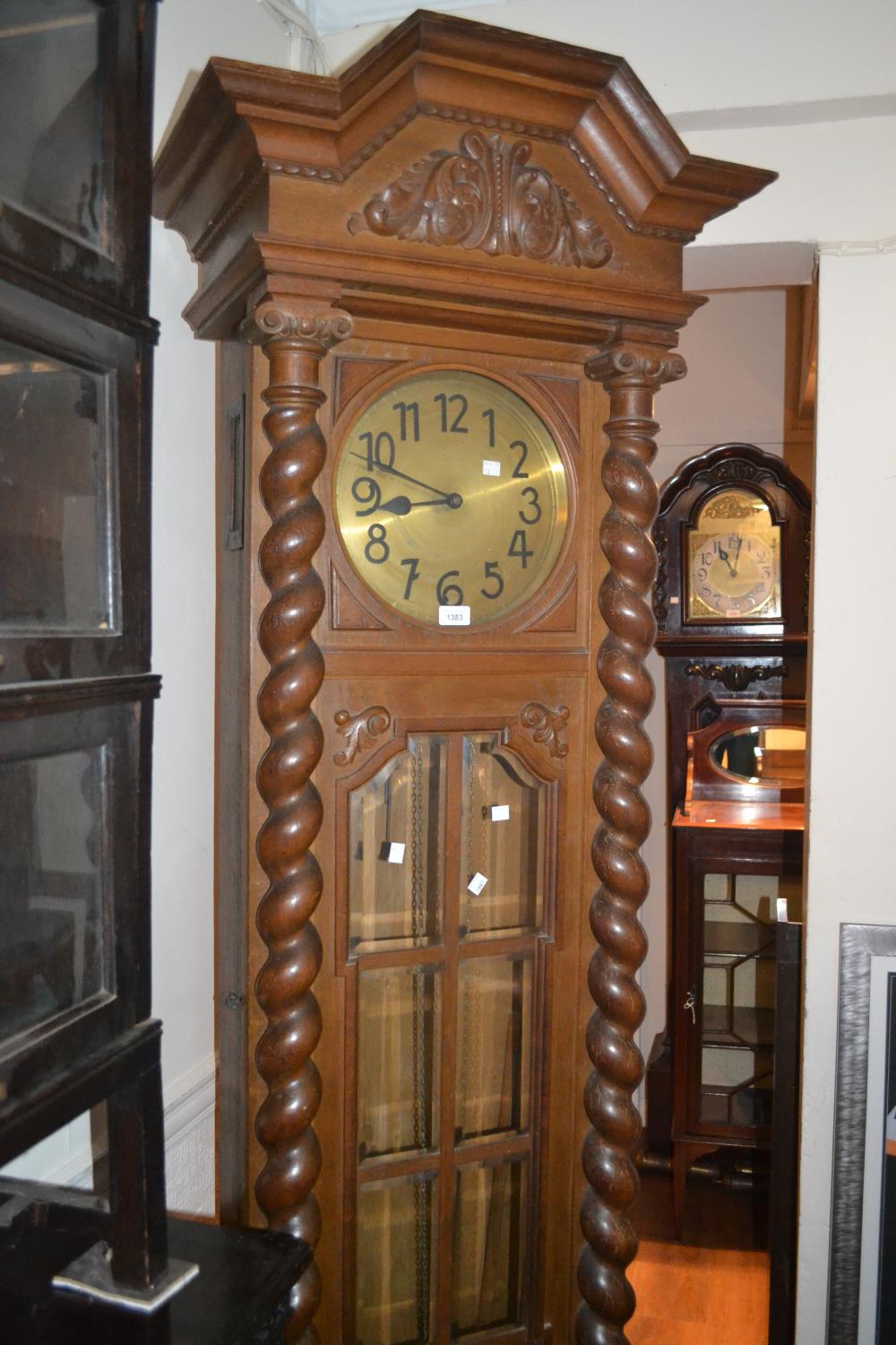 Early 20th Century oak longcase clock, the shaped moulded pediment with a carved floral cresting