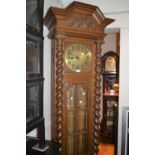 Early 20th Century oak longcase clock, the shaped moulded pediment with a carved floral cresting