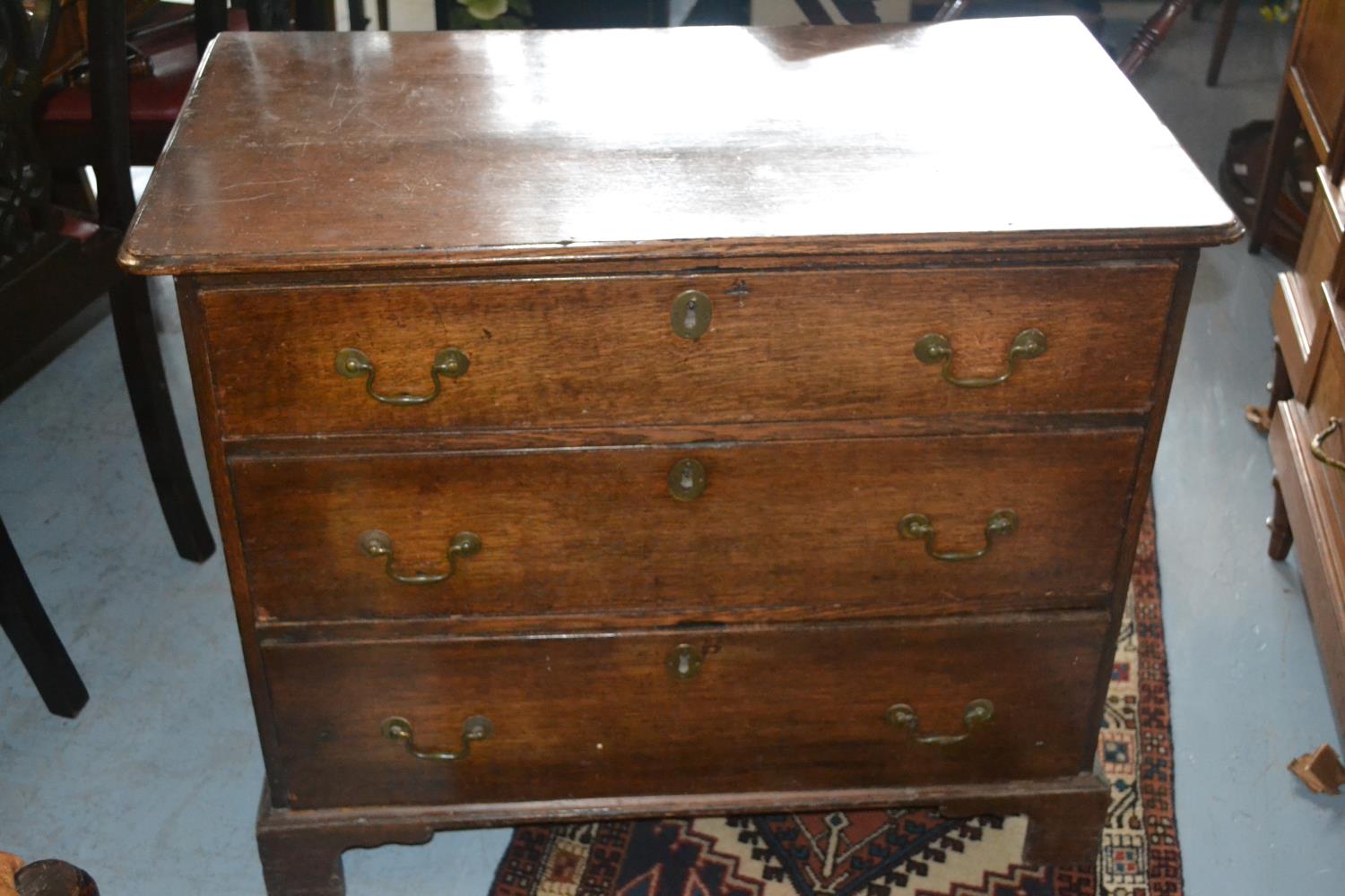 George III oak chest, the moulded top above three drawers with brass swan neck handles and
