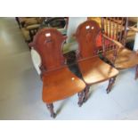Pair of 19th Century walnut hall chairs having carved shield backs and turned tapering front