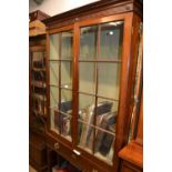 George III mahogany bookcase, the moulded dentil cornice above two astragal glazed doors, the base