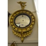 Regency circular gilt framed ball pattern convex mirror with an eagle surmount