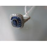 Platinum ring set central sapphire and a halo of calibre cut sapphires and diamonds