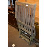 Four matching folding teak garden armchairs (one at fault)