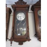 Early 20th Century Continental beechwood Vienna style wall clock with a carved surmount decorated