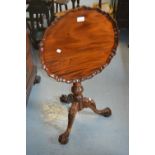 Reproduction mahogany wine table with a pie crust top, bird cage base and carved tripod