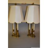 Pair of brass three light table lamps in the form of candles with matching shades, 30ins high