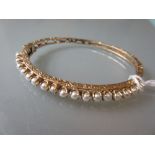 Yellow gold pearl set bangle with safety clip (at fault) Total weight is 10.5g