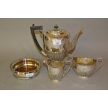 Silver plated pedestal coffee pot, similar cream jug and sugar bowl and a plated wine bottle coaster