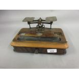 Pair of early 20th Century brass balance scales on walnut base with single drawer lacking weights