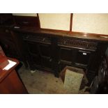 Oak sideboard with two carved drawers above panelled doors on stile feet