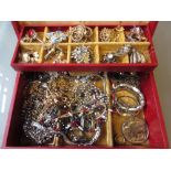 Red jewellery box containing a quantity of various costume jewellery
