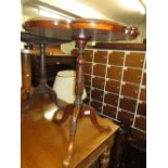 Reproduction mahogany pedestal table with shaped moulded top above a turned and carved column