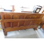 Arts and Crafts oak panelled bedstead together with a side cabinet having open shelves above two