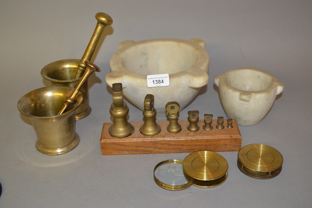 Two bronze pestles and mortars, two marble mortars, two brass lenses and a graduated set of brass