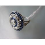 Platinum ring set central diamond surrounded by calibre cut sapphires, a halo of diamonds and
