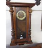 Early 20th Century walnut Vienna style wall clock with turned deoration, the circular dial with