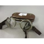 Pair of clear motorcycle goggles in metal case Diameter of frame from left to right is 4.5ins