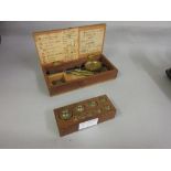 Boxed set of small balance scales and a set of weights on pine stand